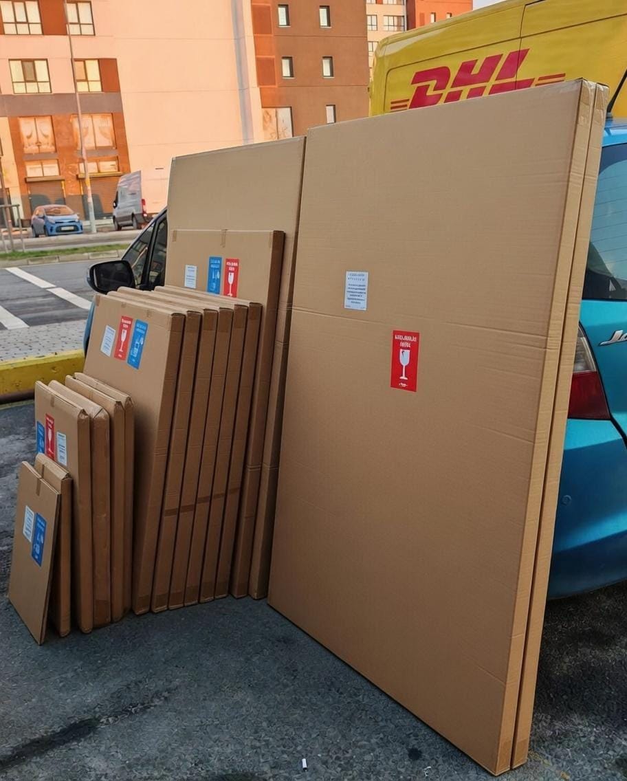 A collection of cardboard boxes and a DHL van are visible in the image.